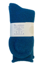 A pair of folded teal blue knit socks with a white paper label band in the center, photographed on a light textured background.